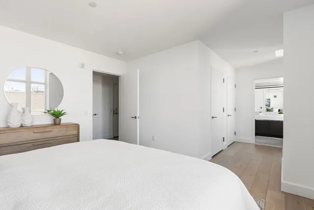 a bedroom with a bed and a large mirror