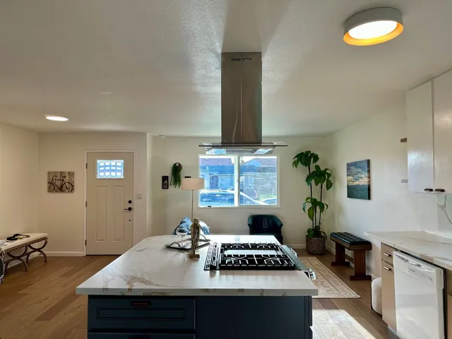a bedroom with a large bed a potted plant and a window