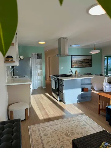 a kitchen with stainless steel appliances granite countertop a sink and wooden floors