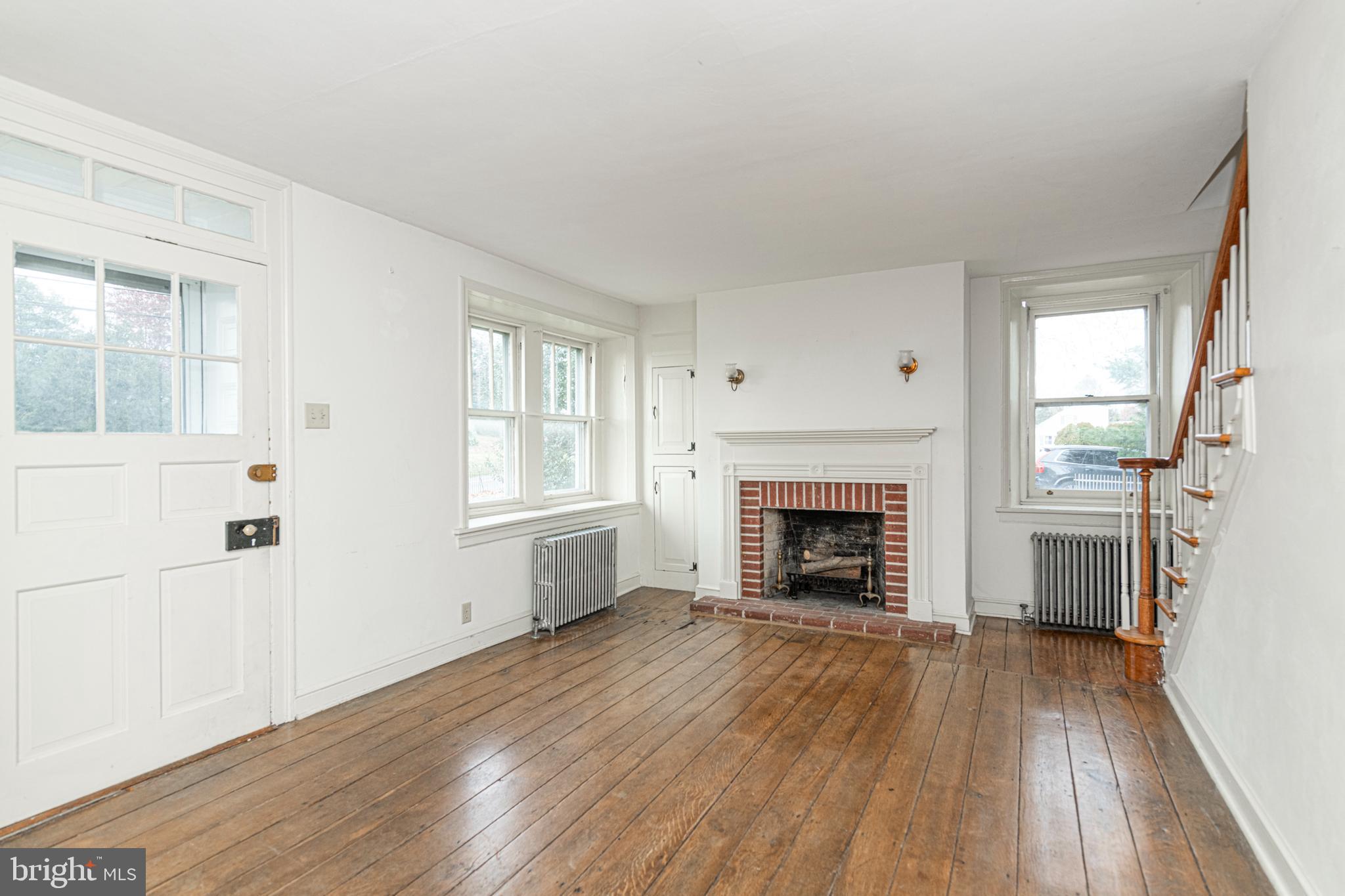 804 Sanatoga Road Pottstown, PA 19465 - Photo 12 of 28 wooden floor fireplace and windows in an empty room