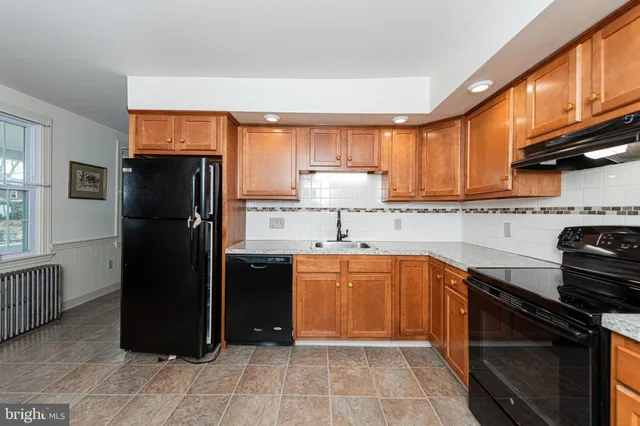 a kitchen with stainless steel appliances granite countertop a refrigerator stove and sink