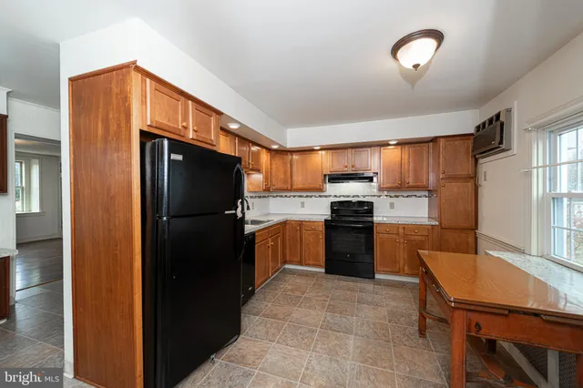 a kitchen with granite countertop a refrigerator stove top oven and sink