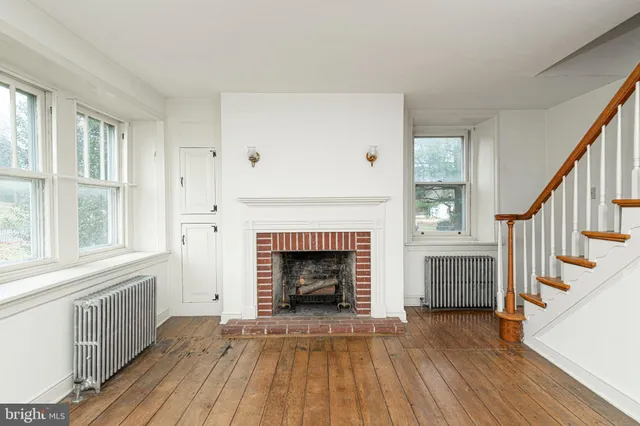 a view of a livingroom with wooden floor and a fireplace