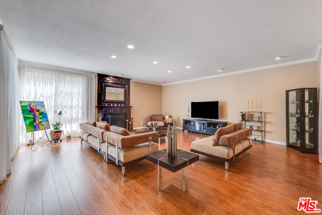 a living room with furniture wooden floor and a flat screen tv