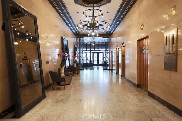 a view of a hallway with couches and chandelier