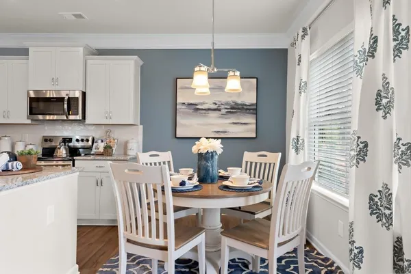 a kitchen with a dining table chairs and a refrigerator