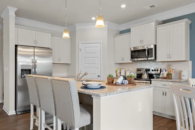 a kitchen with stainless steel appliances granite countertop a sink stove refrigerator and microwave