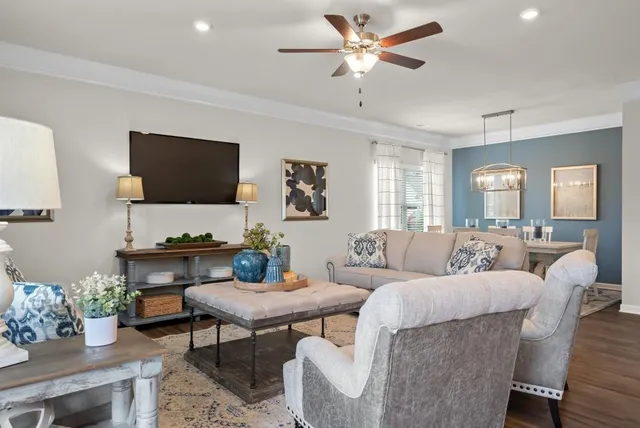 a living room with furniture a flat screen tv and a chandelier
