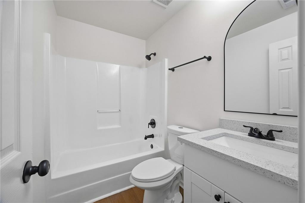 444 McGiboney Road Covington, GA 30016 - Photo 15 of 26 a bathroom with a granite countertop sink a toilet and a mirror