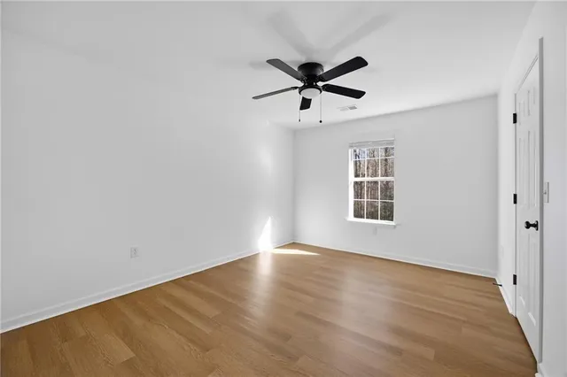 a view of a big room with wooden floor closet and windows