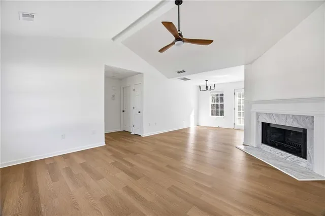 a view of empty room with wooden floor fireplace and a window