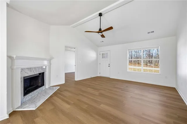 a view of empty room with fireplace and windows