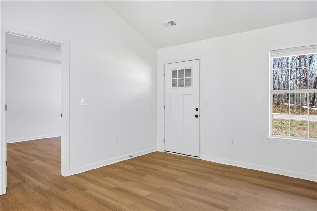 444 McGiboney Road Covington, GA 30016 - Photo 10 of 26 a view of an empty room with wooden floor and a window