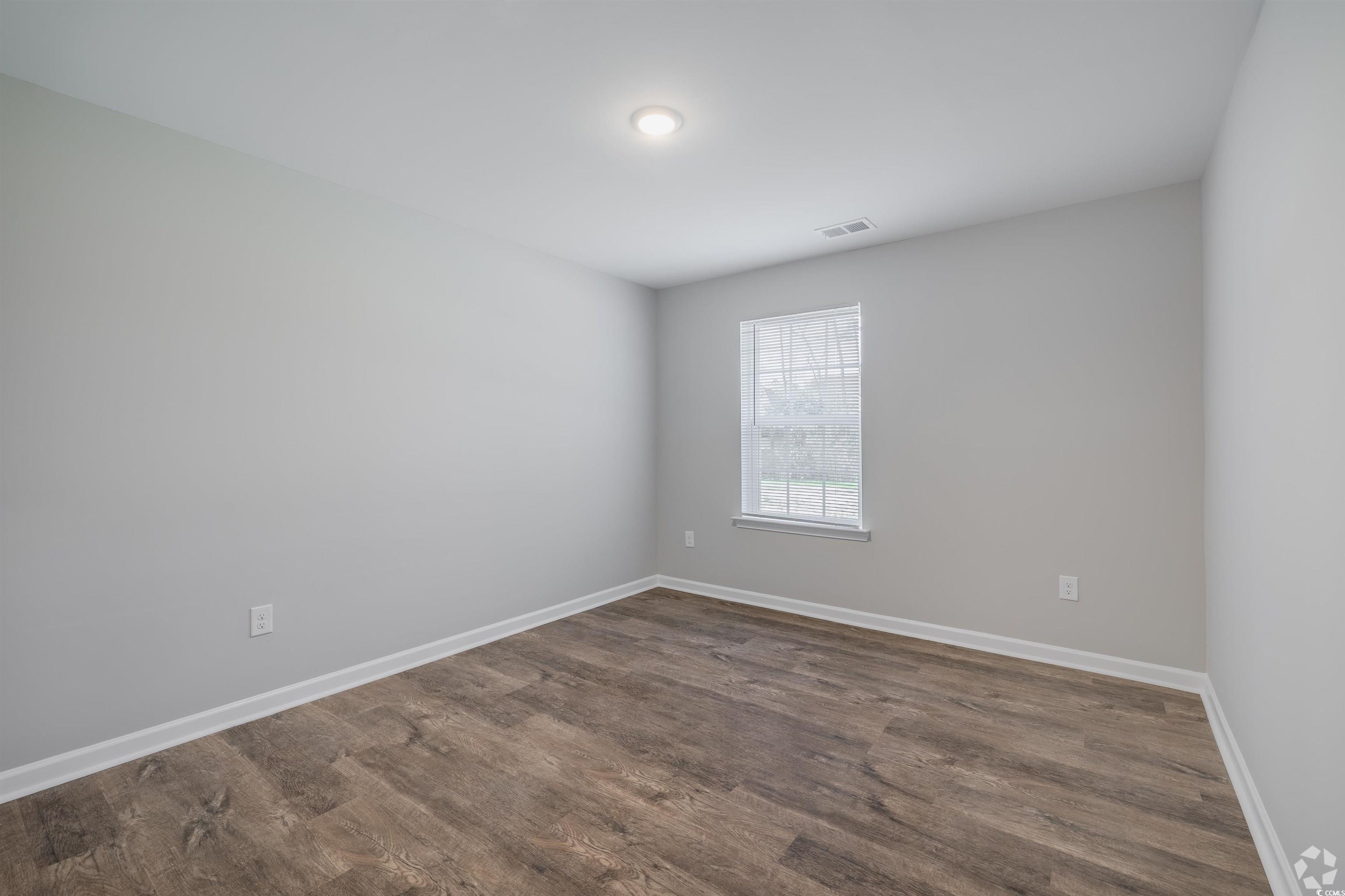 318 South Black Swamp Court, Unit 202 Conway, SC 29526 - Photo 5 of 8 Spare room featuring dark wood-type flooring and baseboards