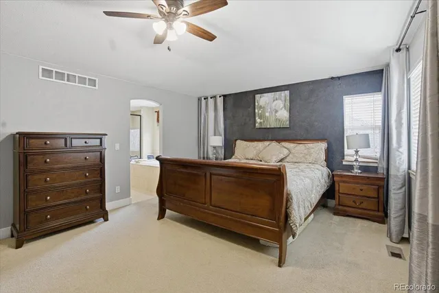 a spacious bathroom with a tub sink and mirror