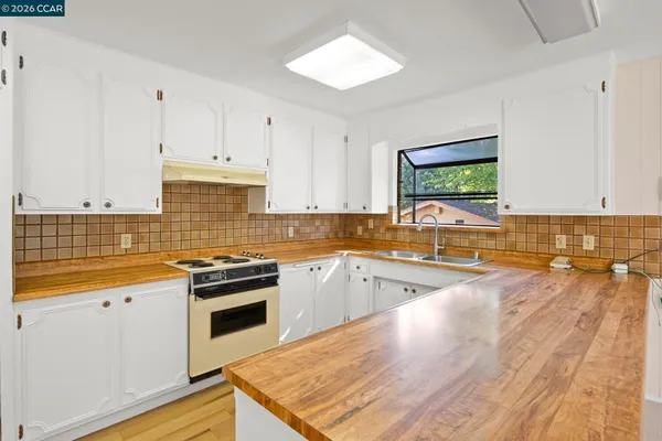 a kitchen with granite countertop a stove and cabinets