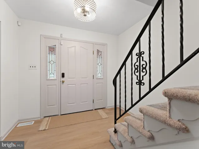 a view of entryway and hall with wooden floor