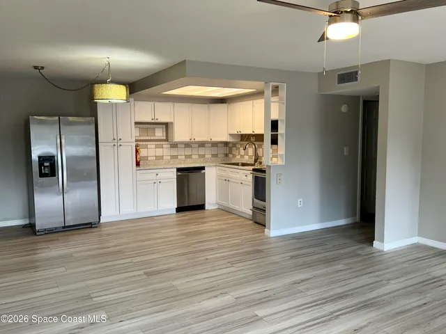 a kitchen with stainless steel appliances granite countertop a refrigerator and a stove