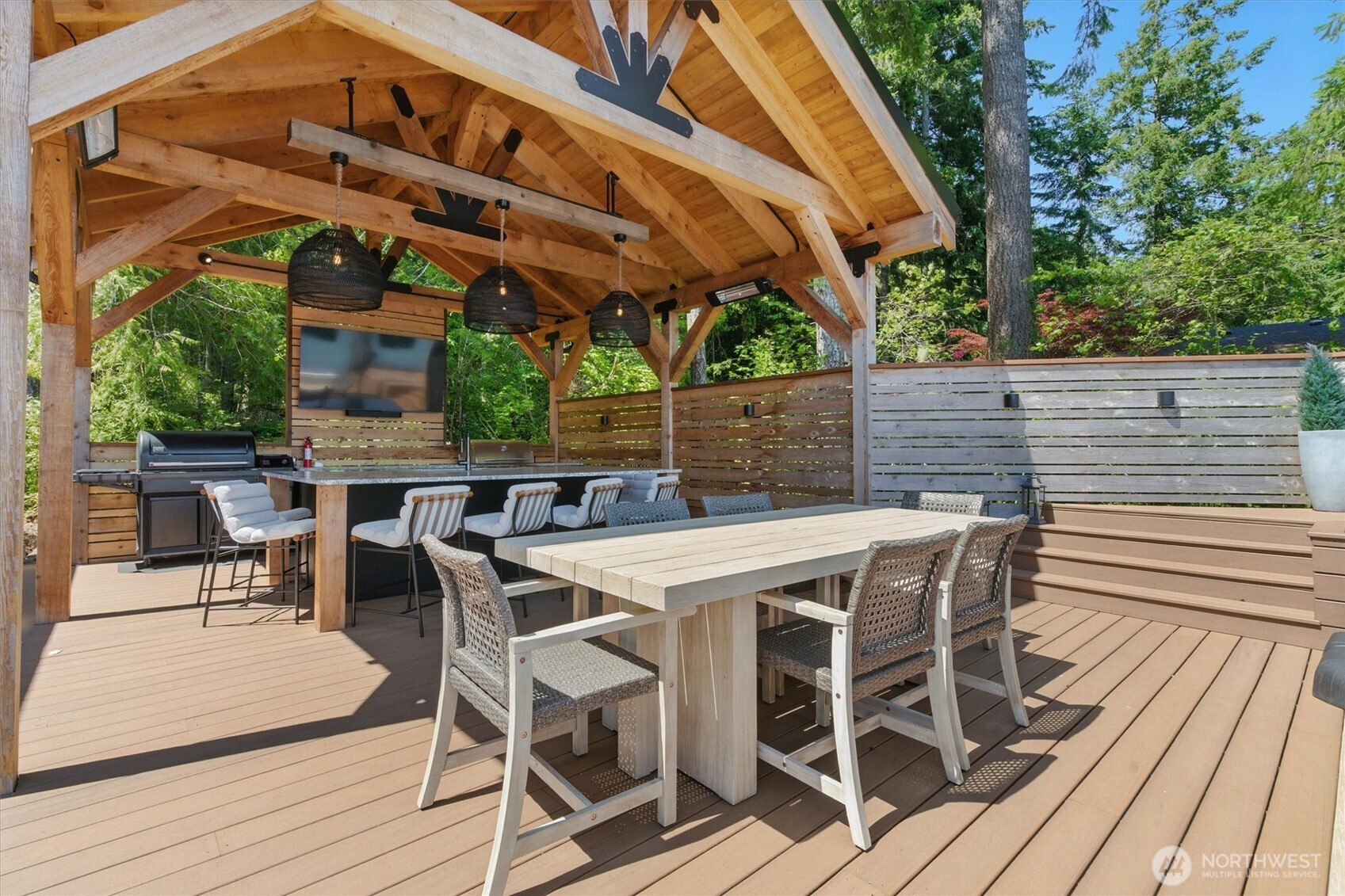 6570 East Grapeview Loop Road Allyn, WA 98524 - Photo 13 of 38 a view of a patio with table and chairs with wooden floor and fence next to a yard