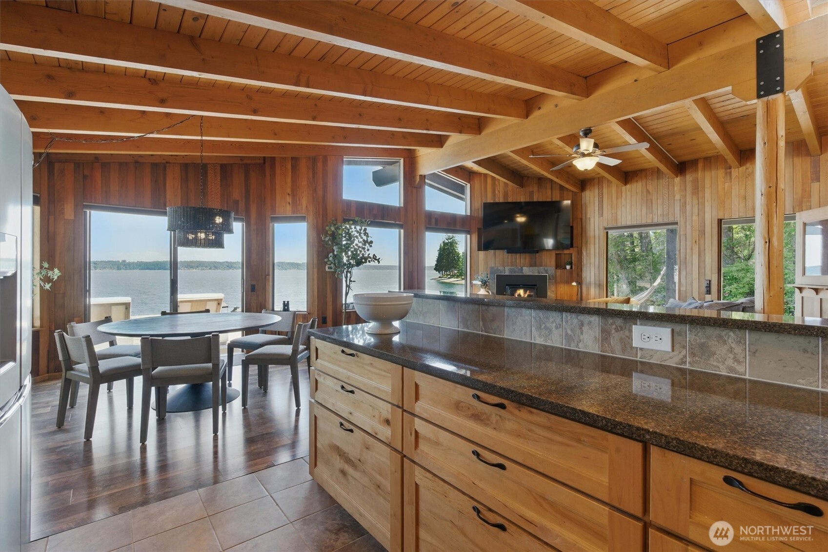 6570 East Grapeview Loop Road Allyn, WA 98524 - Photo 7 of 38 a kitchen with stainless steel appliances granite countertop a table chairs and a wooden cabinets