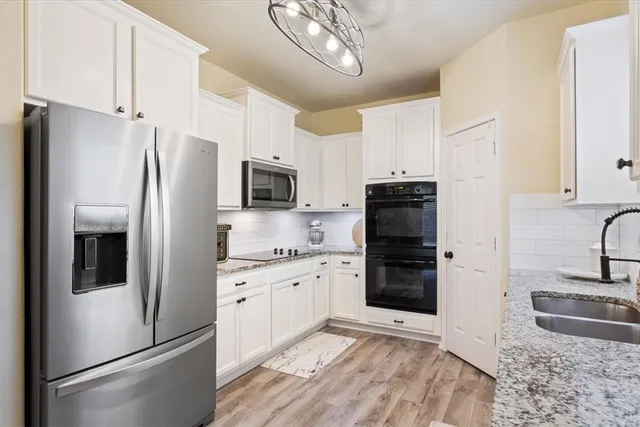 a kitchen with stainless steel appliances granite countertop a refrigerator stove and sink