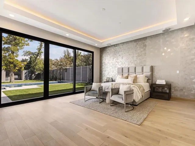 a spacious bedroom with a bed and large glass window