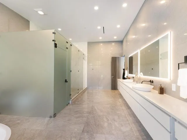 a bathroom with a double vanity sink mirror and shower