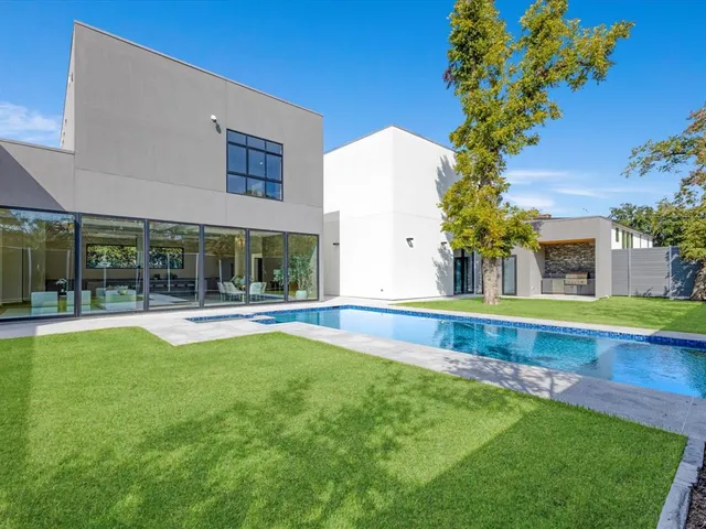 a view of a house with swimming pool and a yard