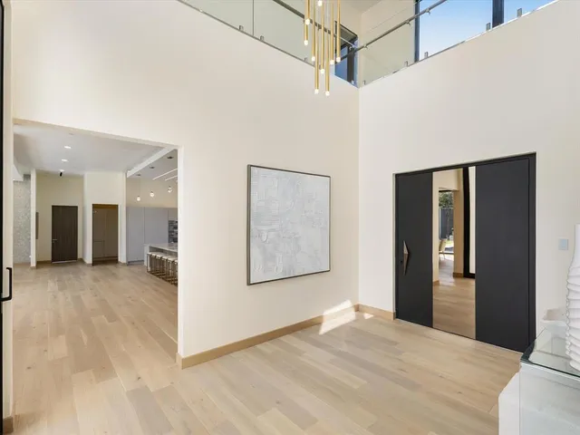 a view of a big room with wooden floor and windows