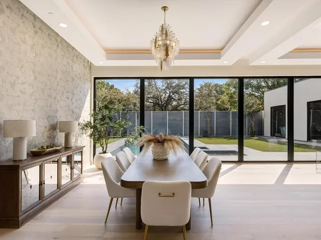 a view of a dining room with furniture large windows and wooden floor