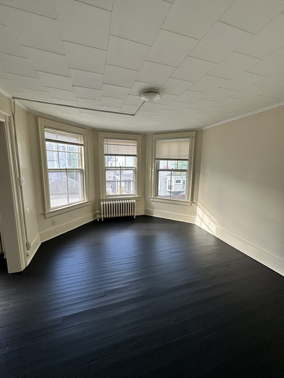 3 Marston Way Worcester, MA 01609 - Photo 19 of 25 an empty room with wooden floor and windows with curtains