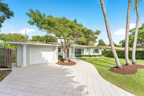 a front view of a house with a yard and potted plants