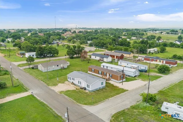an aerial view of a house with a garden and lake view