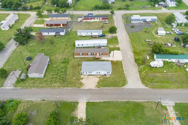an aerial view of residential houses with outdoor space and swimming pool