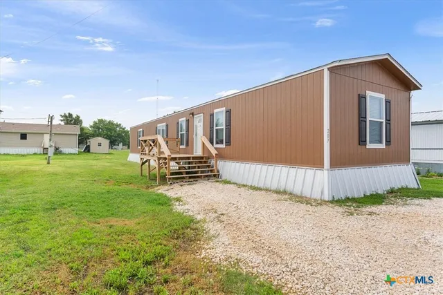 a view of a house with backyard and sitting area