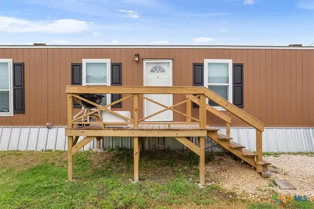 a house view with a wooden fence and a chair