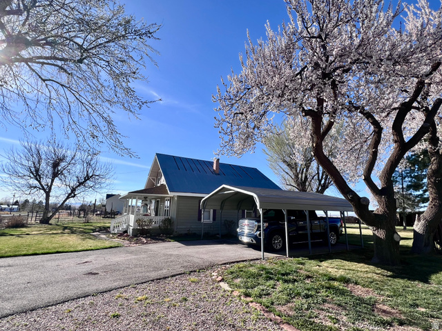 479 East 100 N Road Meadow, UT 84644 - Photo 54 of 59 View of side of home featuring a porch, a metal roof, driveway, a yard, and a carport