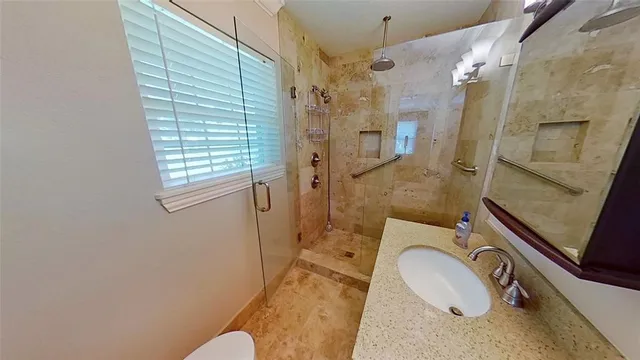 a bathroom with a sink a toilet and shower