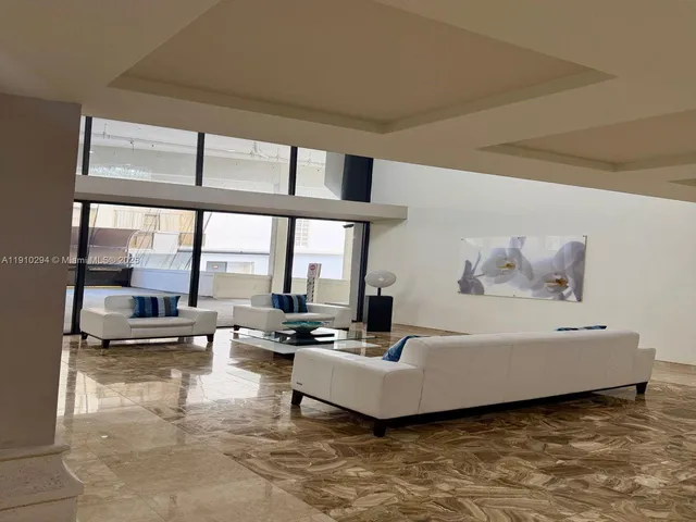 a living room with furniture and floor to ceiling windows