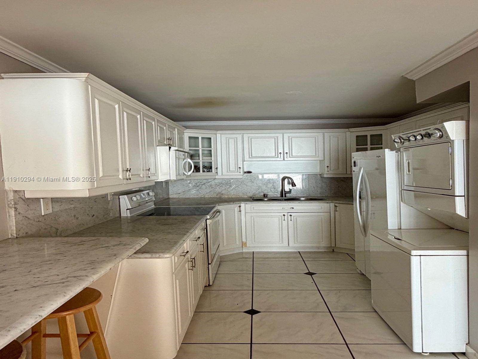 6061 Collins Avenue, Unit 11A Miami Beach, FL 33140 - Photo 15 of 30 a kitchen with stainless steel appliances granite countertop a sink stove and refrigerator