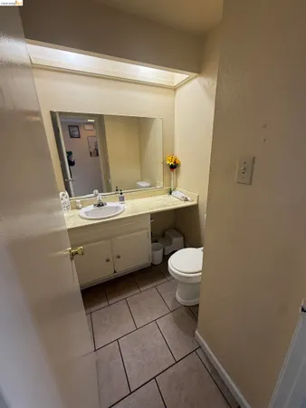 a bathroom with a toilet a sink a mirror and vanity