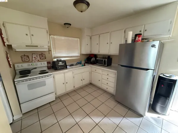 a kitchen with a refrigerator sink and cabinets