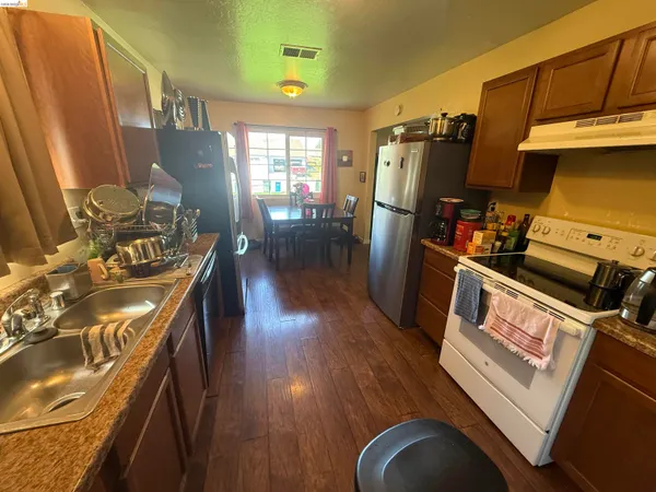 a kitchen with stainless steel appliances granite countertop a refrigerator stove and sink