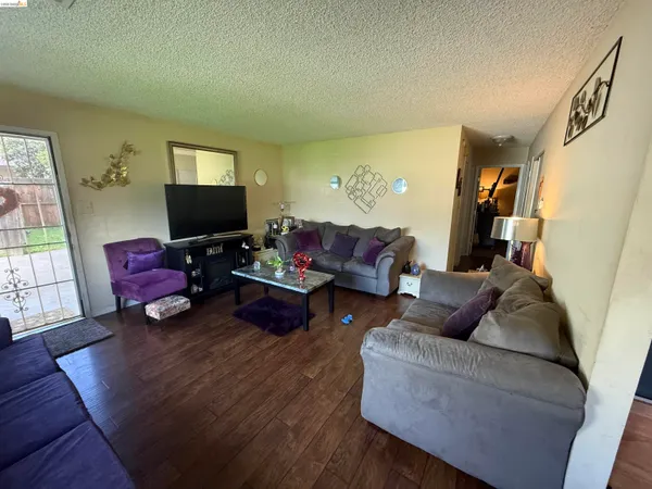 a living room with furniture and a flat screen tv with wooden floor