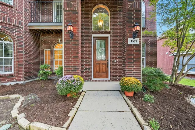 a view of a brick house with a large windows and a potted plant