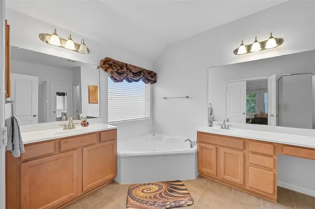 a spacious bathroom with a double vanity sink a mirror and a bathtub
