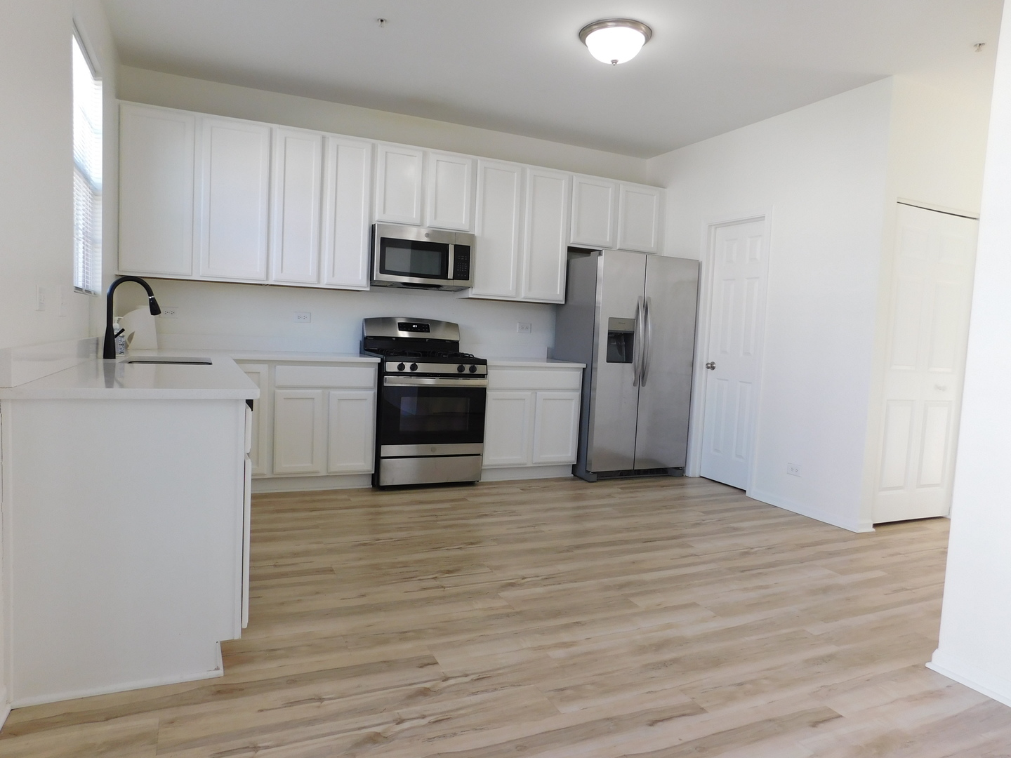 3748 Bailey Road, Unit 3748 Yorkville, IL 60560 - Photo 7 of 27 a kitchen with stainless steel appliances a sink cabinets and wooden floor
