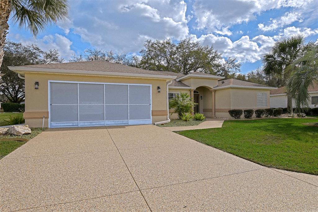 8850 Southeast 140th Place Road Summerfield, FL 34491 - Photo 24 of 98 front view of a house with a garden and a garage