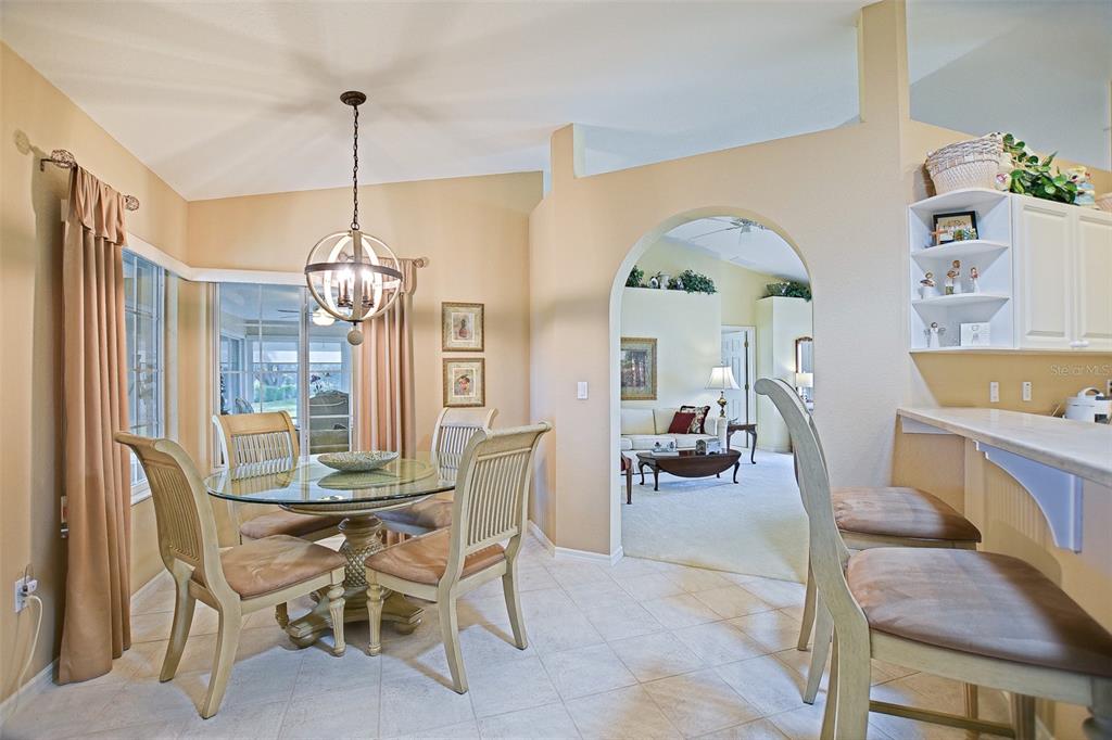 8850 Southeast 140th Place Road Summerfield, FL 34491 - Photo 46 of 98 a view of a dining room and livingroom with furniture wooden floor a chandelier