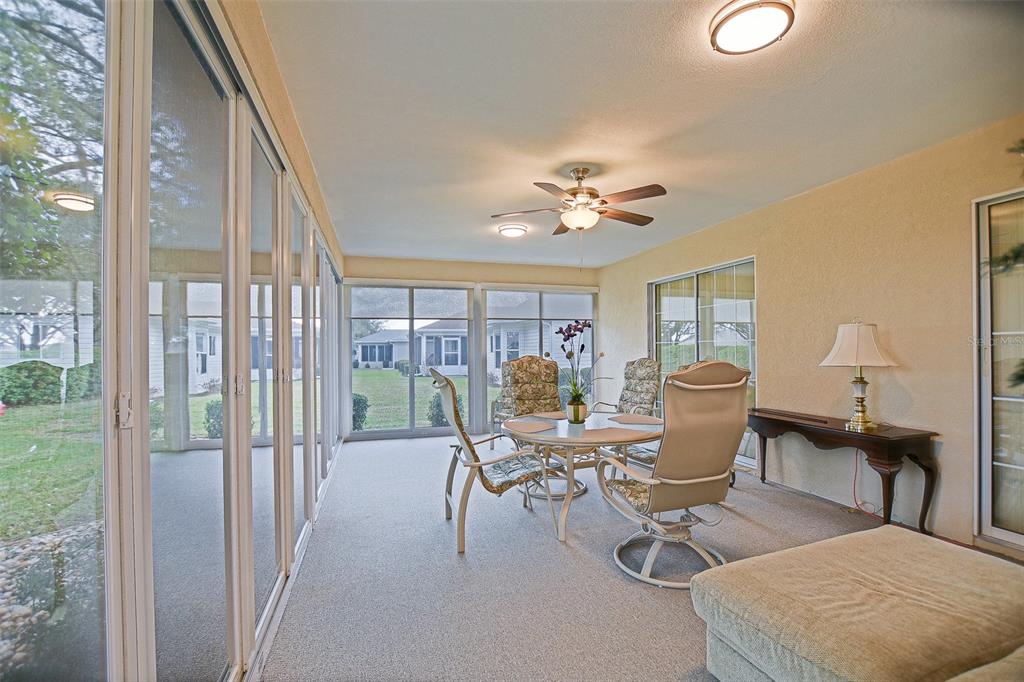 8850 Southeast 140th Place Road Summerfield, FL 34491 - Photo 55 of 98 a living room with furniture a lamp and a floor to ceiling window